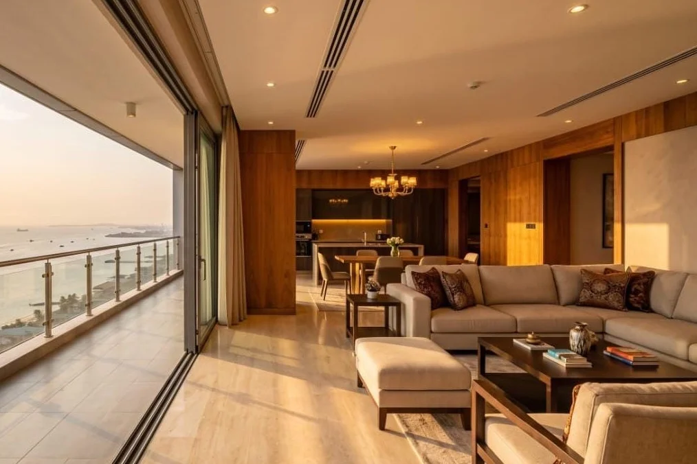 An open-plan living room with floor-to-ceiling windows over the water