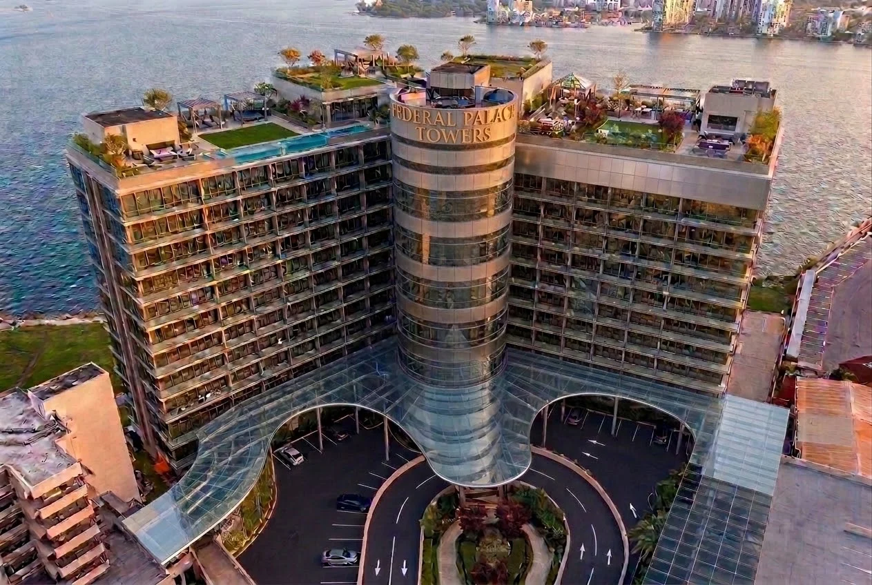 Aerial view of FPH Towers on the Lagos waterfront, its curved central tower rising between two residential wings